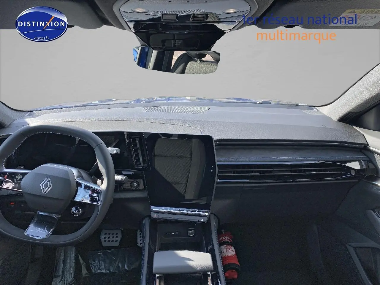Vue intérieure avant du Renault Austral 2025 bleu iron, tableau de bord moderne avec écran tactile vertical et volant multifonction.