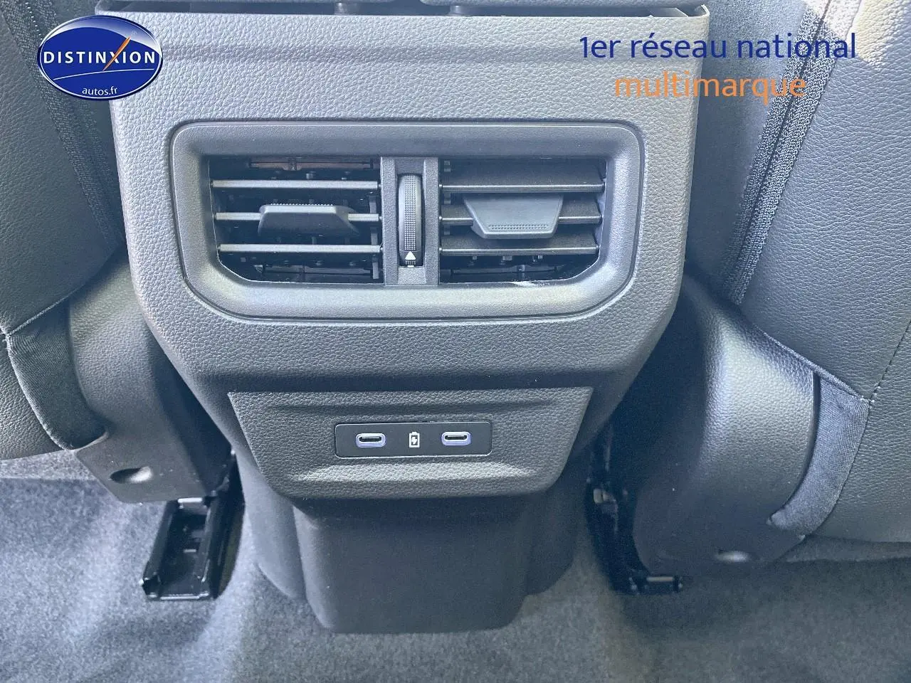 Prise USB double et bouche d'aération arrière entre les sièges avant d'un Renault Austral bleu iron t/noir éto 2025.