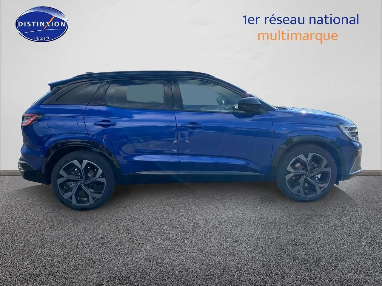 Profil côté gauche du Renault Austral hybride 2025 en bleu iron avec toit noir et jantes alu distinctives.