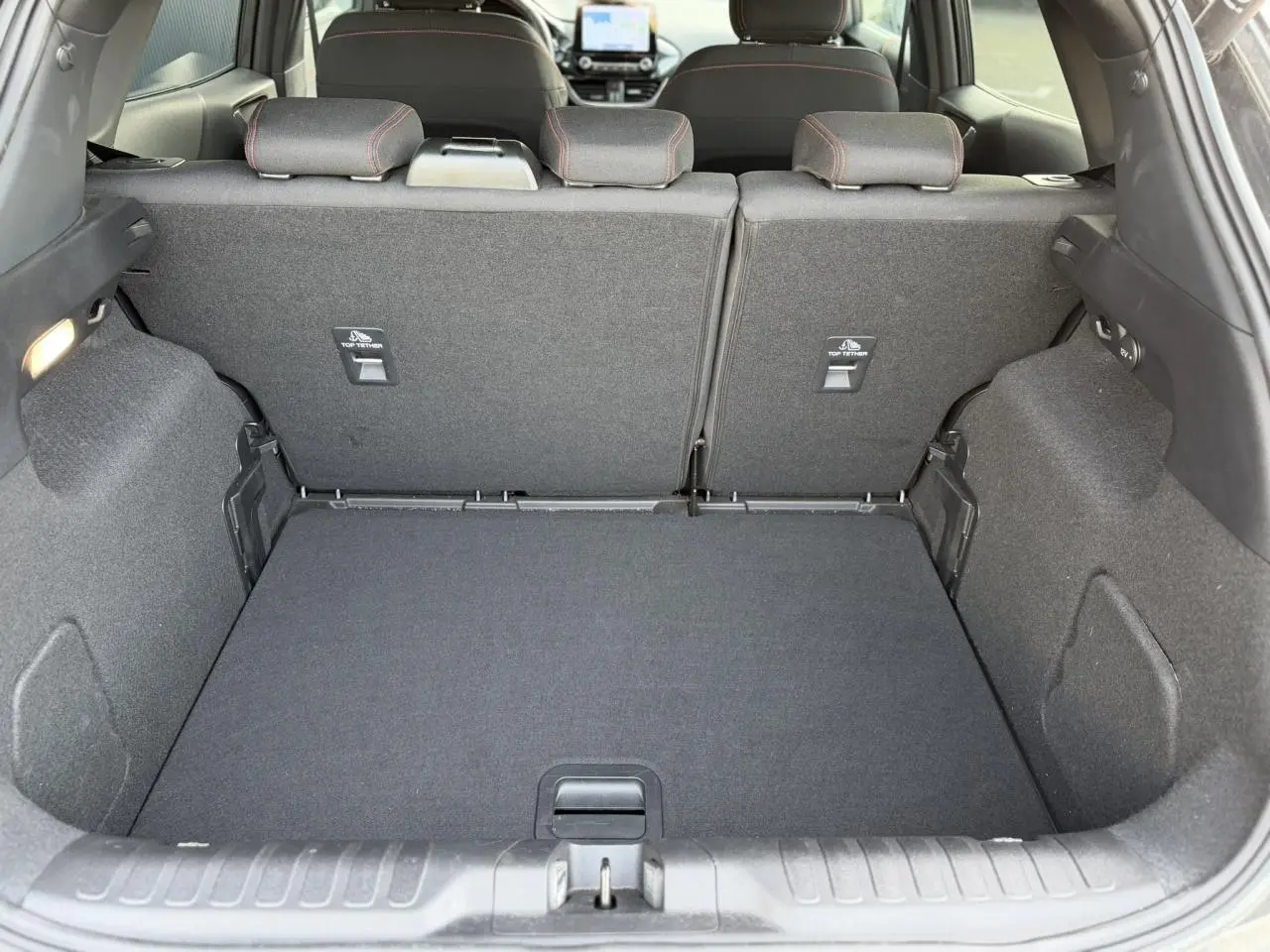 Vue intérieure du coffre arrière du Ford Puma 2024 gris magnétique, montrant les dossiers de sièges arrière et le plancher plat.