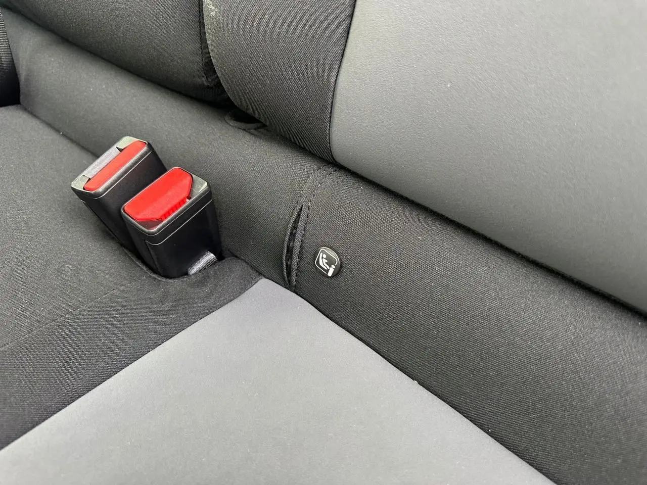 Gros plan sur la banquette arrière noire avec fixation Isofix et boucles de ceinture rouges du Dacia Sandero III Stepway.