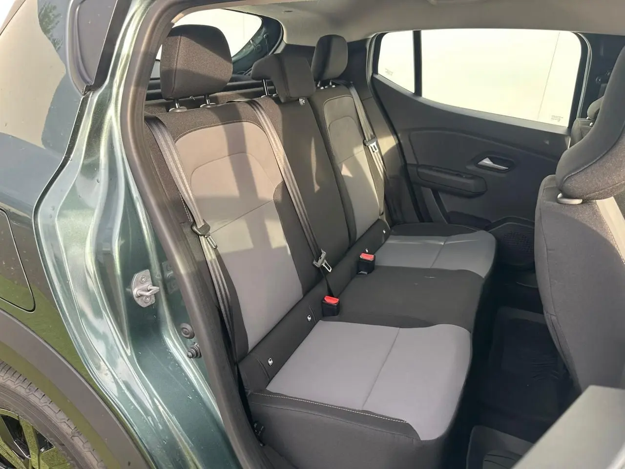 Vue intérieure côté gauche sur la banquette arrière grise et noire du Dacia Sandero III Stepway Vert Cèdre 2025.