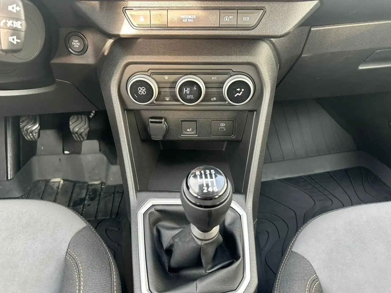 Vue intérieure centrée sur la console centrale et levier de vitesses manuel de la Dacia Sandero III Stepway 2025.