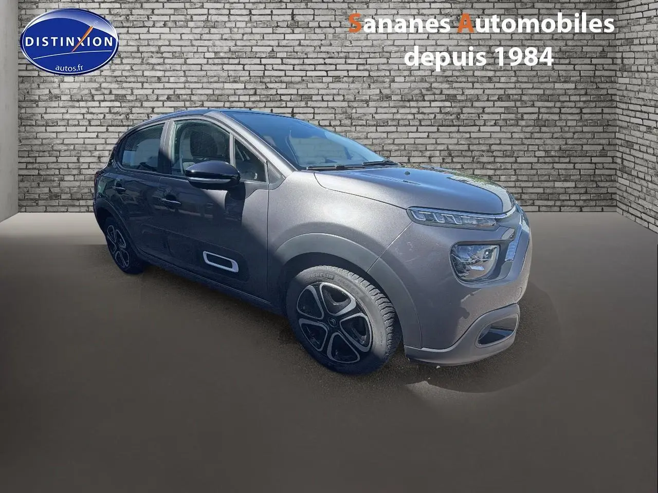 Citroën C3 gris foncé vue 3/4 avant droit, avec Airbump noirs et jantes au design distinctif.