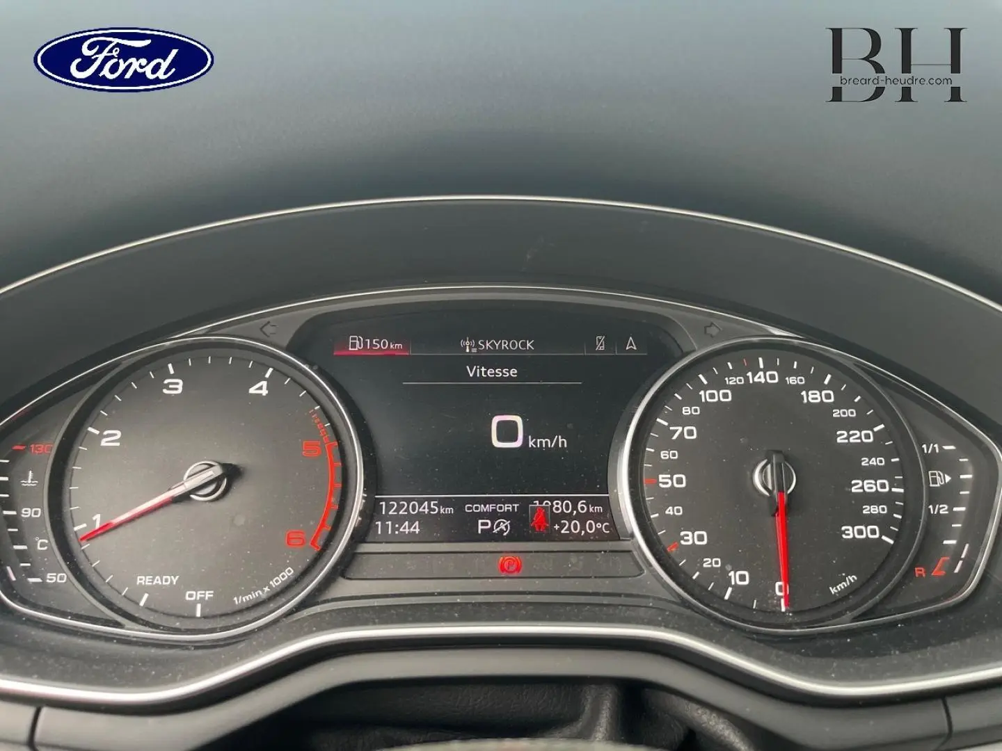 Vue rapprochée du tableau de bord numérique d'une Audi A4 Avant blanc glacier, affichant la vitesse à 0 km/h.