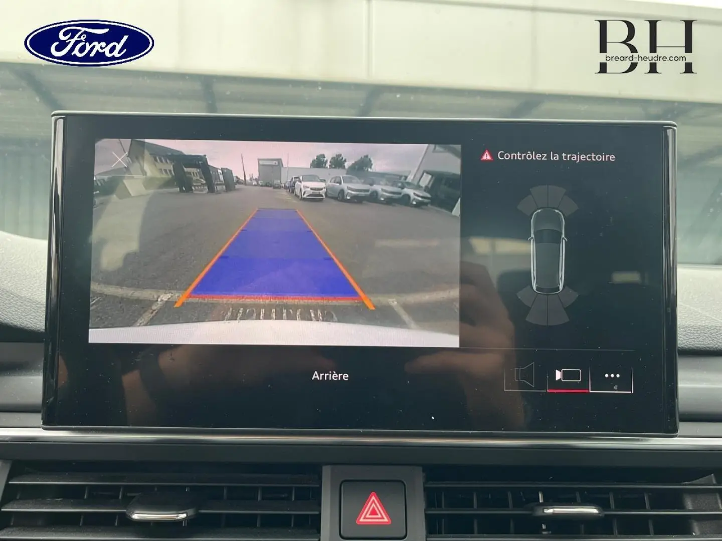Écran central montrant la caméra de recul avec guidage de trajectoire sur Audi A4 Avant blanc glacier, vue intérieure.