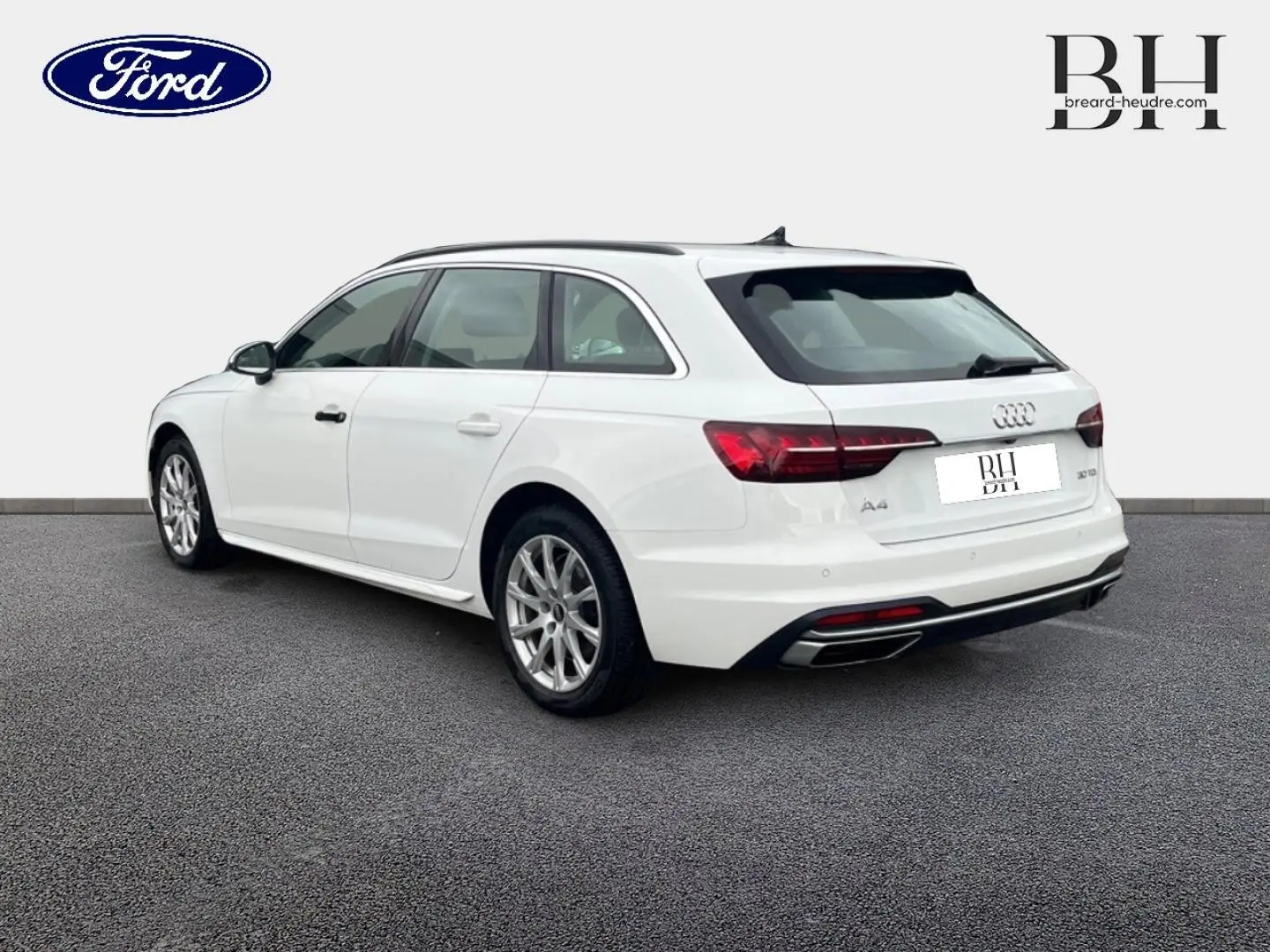 Audi A4 Avant blanc glacier métallisé vue 3/4 arrière droit, avec jantes alu et feux arrière LED distinctifs.