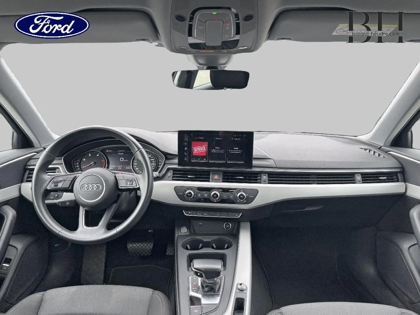 Vue intérieure avant de l'Audi A4 Avant 30 TDI 2021, tableau de bord noir avec écran central et volant cuir multifonction.