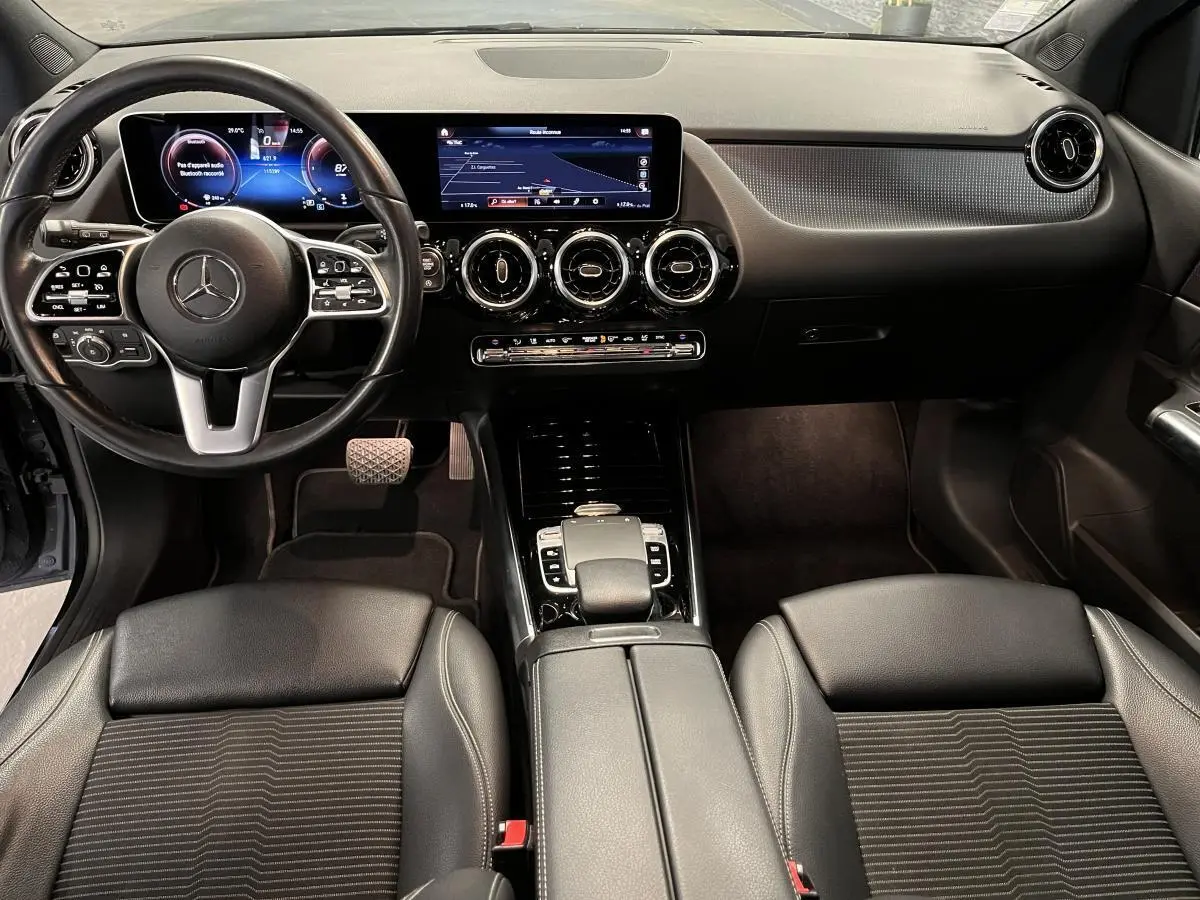 Intérieur noir de la Mercedes Classe B 180 d 2019, vue frontale sur tableau de bord digital et volant multifonction.