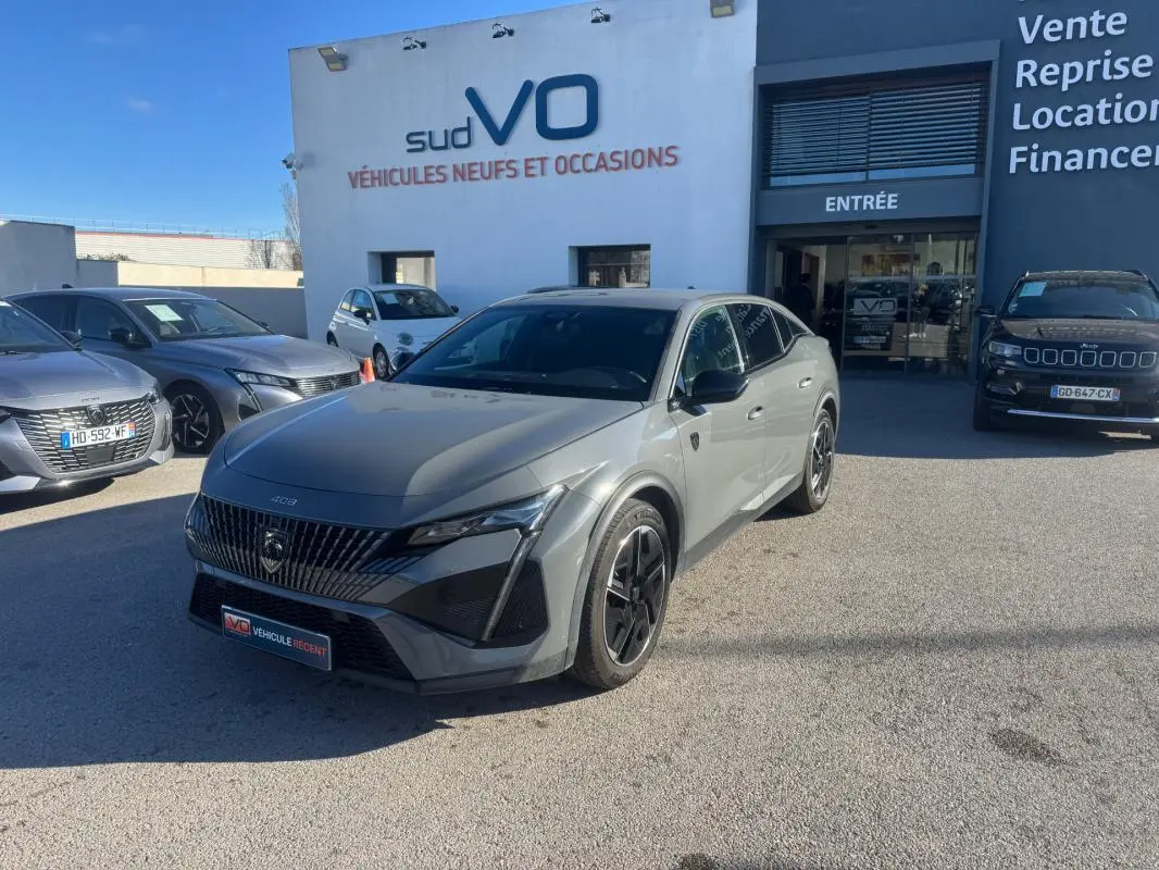 Peugeot 408 Hybrid gris vue 3/4 avant droit, jantes alliage 19 pouces et calandre distinctive au soleil.