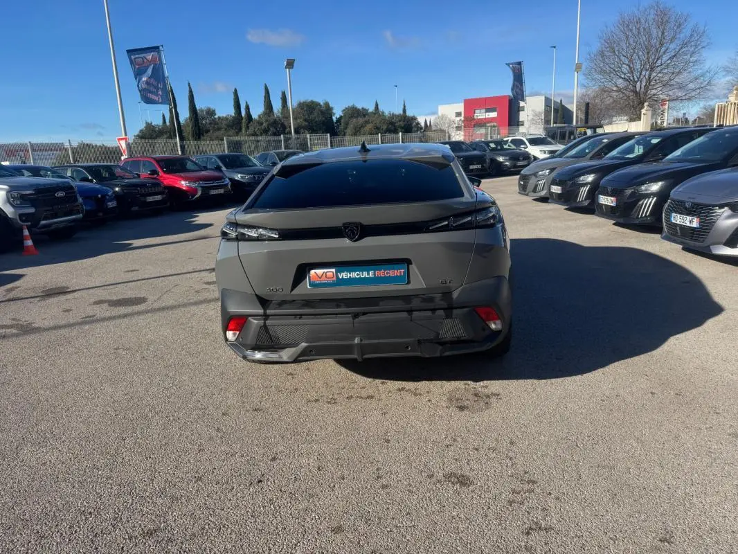 Vue arrière d'une Peugeot 408 gris 2024 Hybrid GT avec feux effilés et jantes alliage 19 pouces.
