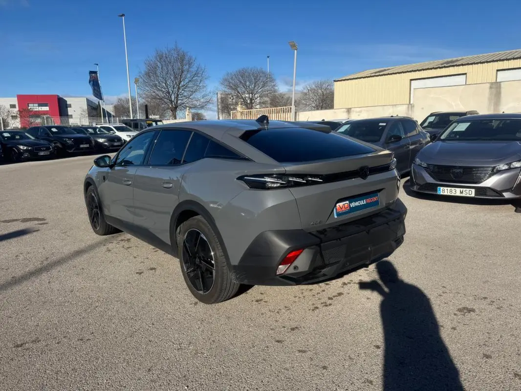 Peugeot 408 Hybrid gris vu en 3/4 arrière droit, avec jantes alliage noires et vitres teintées.