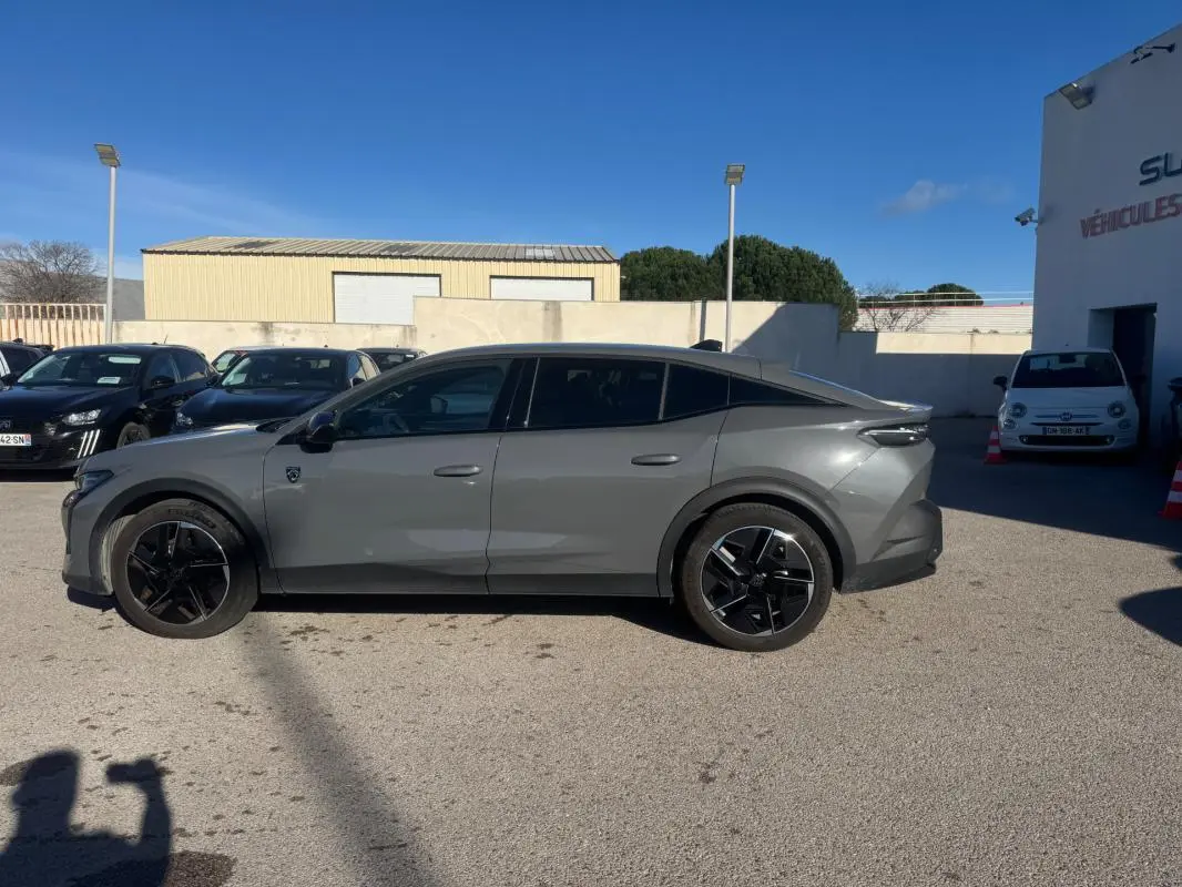 Vue de profil côté gauche d'une Peugeot 408 Hybrid 136 e-DCS6 GT gris avec jantes alliage noires de 19 pouces.