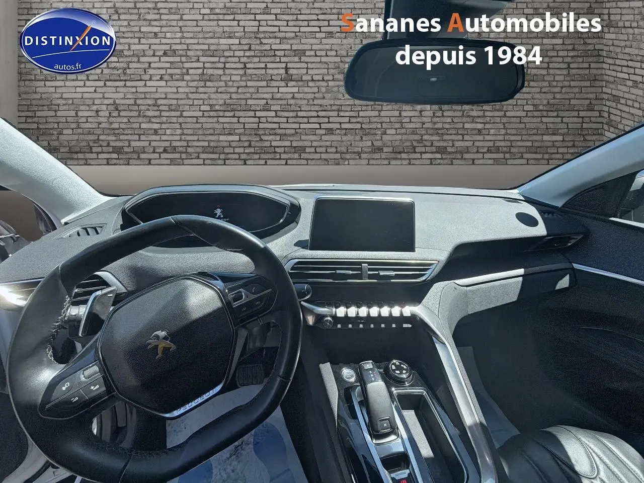 Vue intérieure du tableau de bord et volant noir du Peugeot 3008 blanc, avec écran tactile et console centrale moderne.