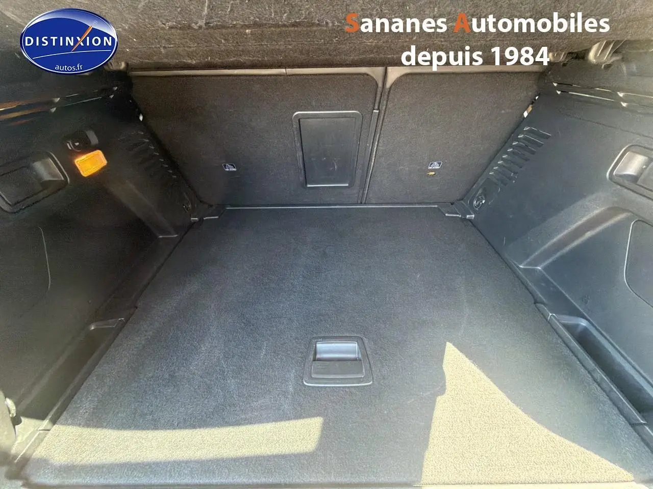 Coffre spacieux et vide du Peugeot 3008 blanc, vue intérieure depuis l'arrière avec revêtement noir et éclairage ambiant.
