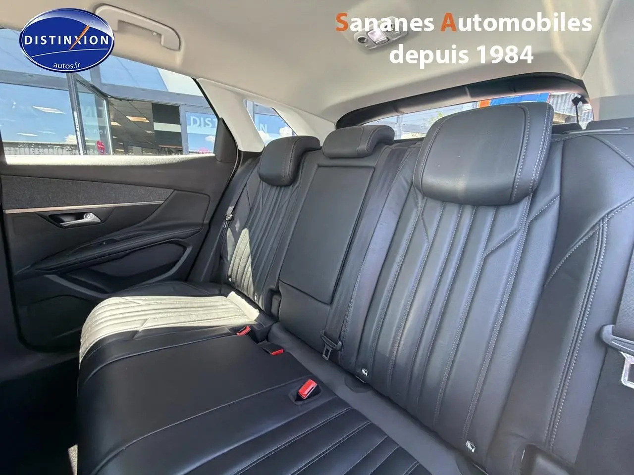Vue intérieure du siège arrière en cuir noir du Peugeot 3008 blanc, avec appuie-têtes et ceintures visibles.
