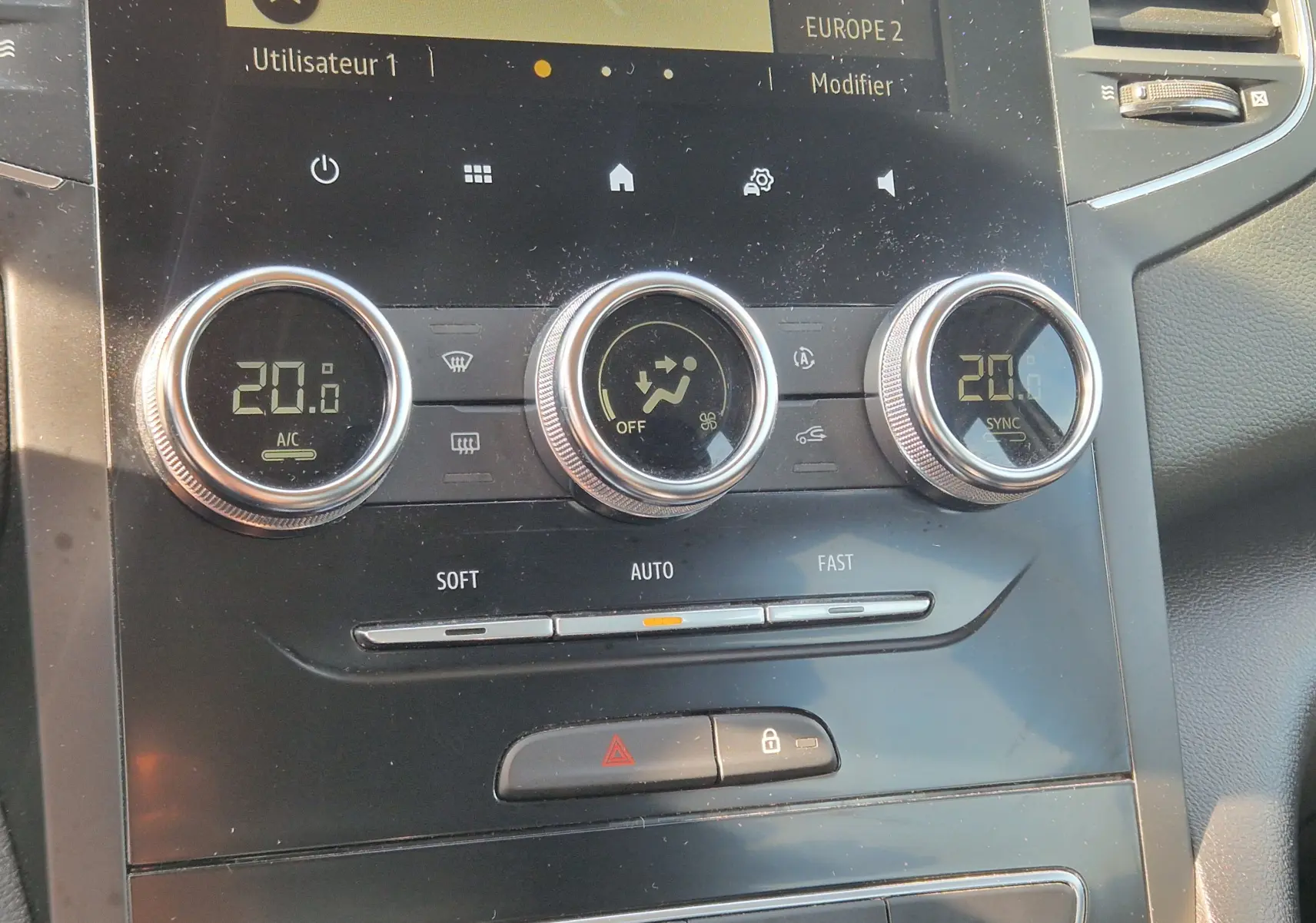 Gros plan sur la console centrale de la Renault Mégane 1.5 Blue dCi 115 Evolution 2022, montrant les commandes de climatisation digitales.