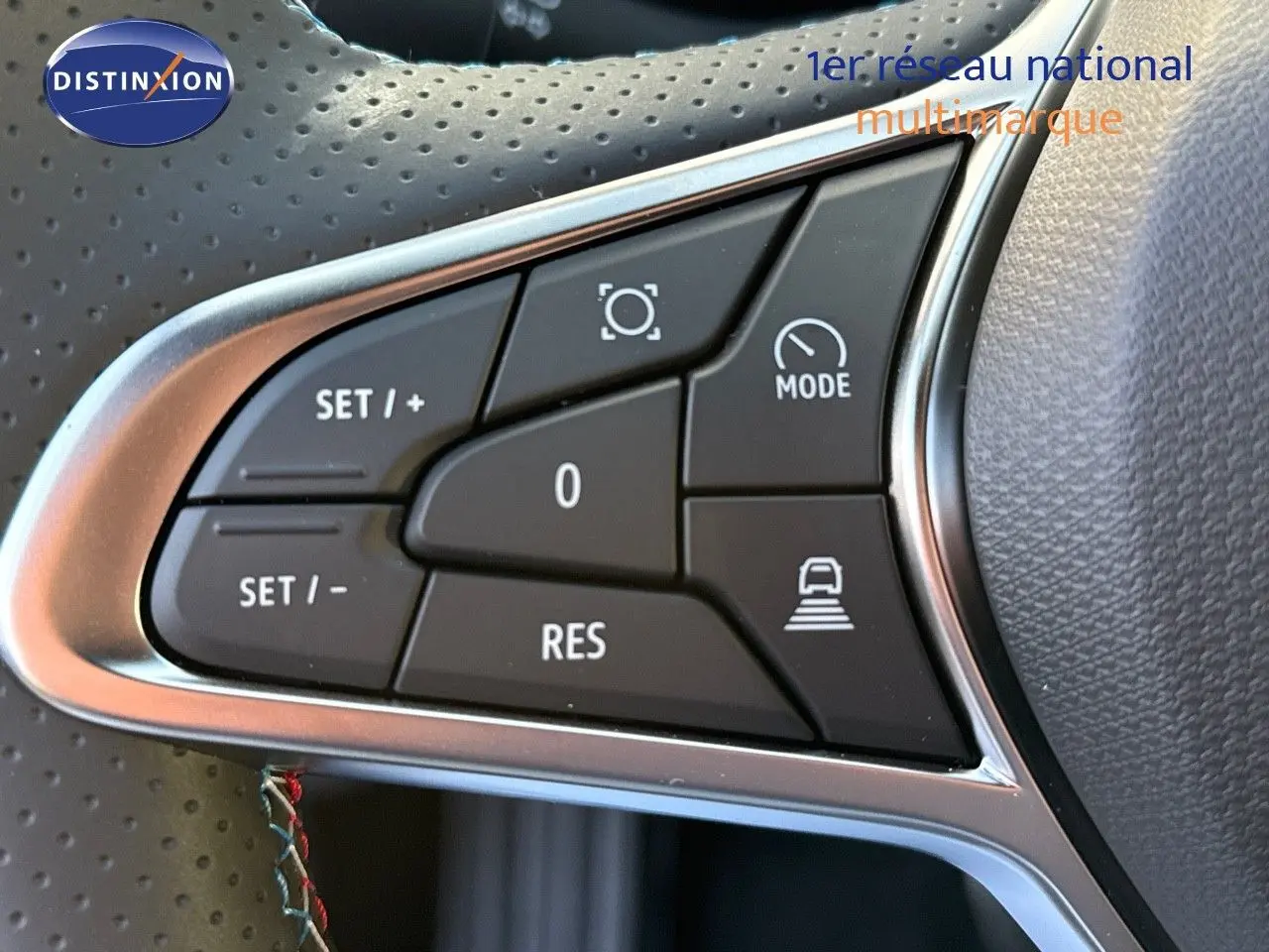 Gros plan sur les commandes de régulateur de vitesse au volant du Renault Symbioz gris Cassiope 2024.