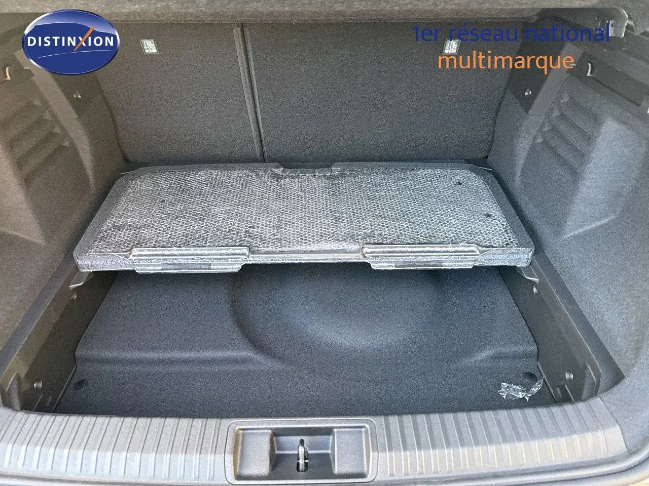 Coffre ouvert du Renault Symbioz gris Cassiope montrant le compartiment de rangement sous le plancher.