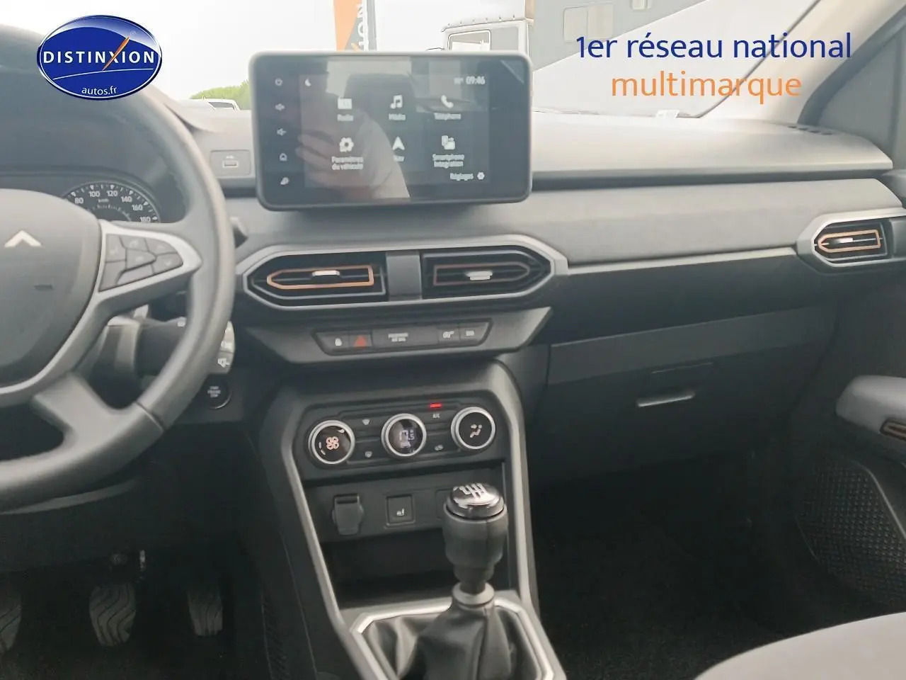 Intérieur avant de la Dacia Sandero 2025 noir, avec tableau de bord moderne et écran tactile central visible.