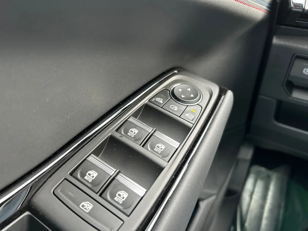 Gros plan sur les commandes des vitres électriques côté conducteur de la Renault Rafale noire esprit Alpine 2025.