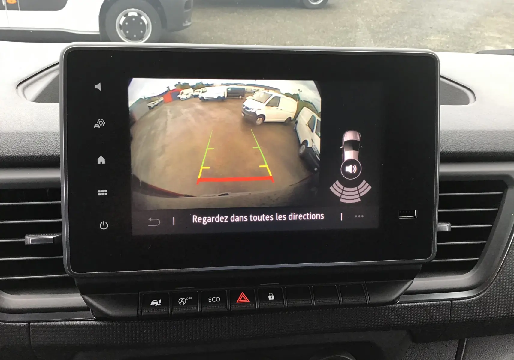 Écran de caméra de recul du Renault Trafic Fourgon blanc L2H1 2023 montrant l'arrière et les véhicules environnants.