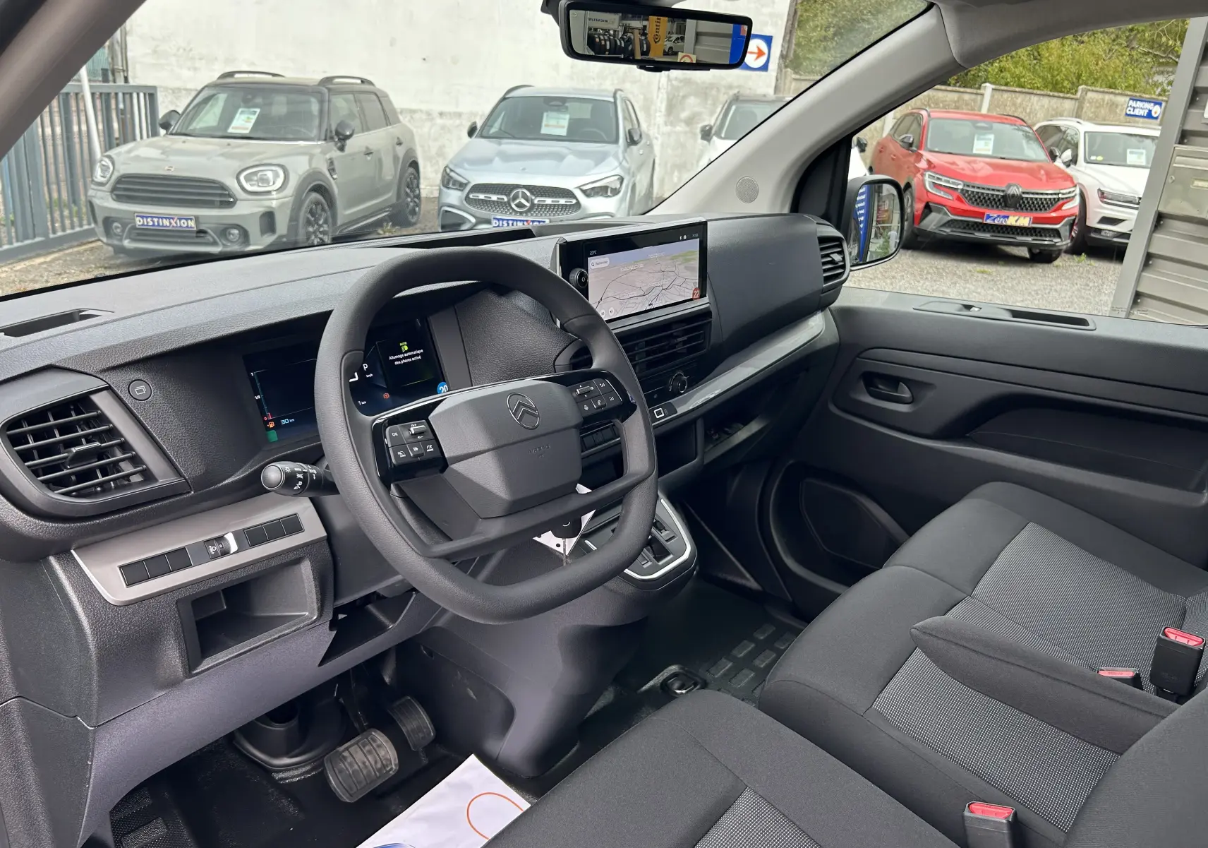 Intérieur côté conducteur du Citroën Jumpy Fourgon gris acier 2025, tableau de bord moderne avec écran tactile et volant multifonction.