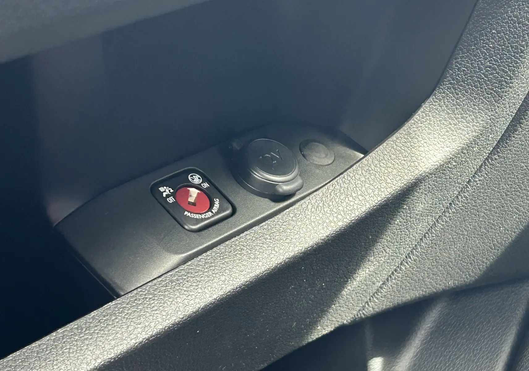 Gros plan sur l'interrupteur d'airbag passager et prise 12V dans l'habitacle du Citroën Jumpy Fourgon gris acier 2025.