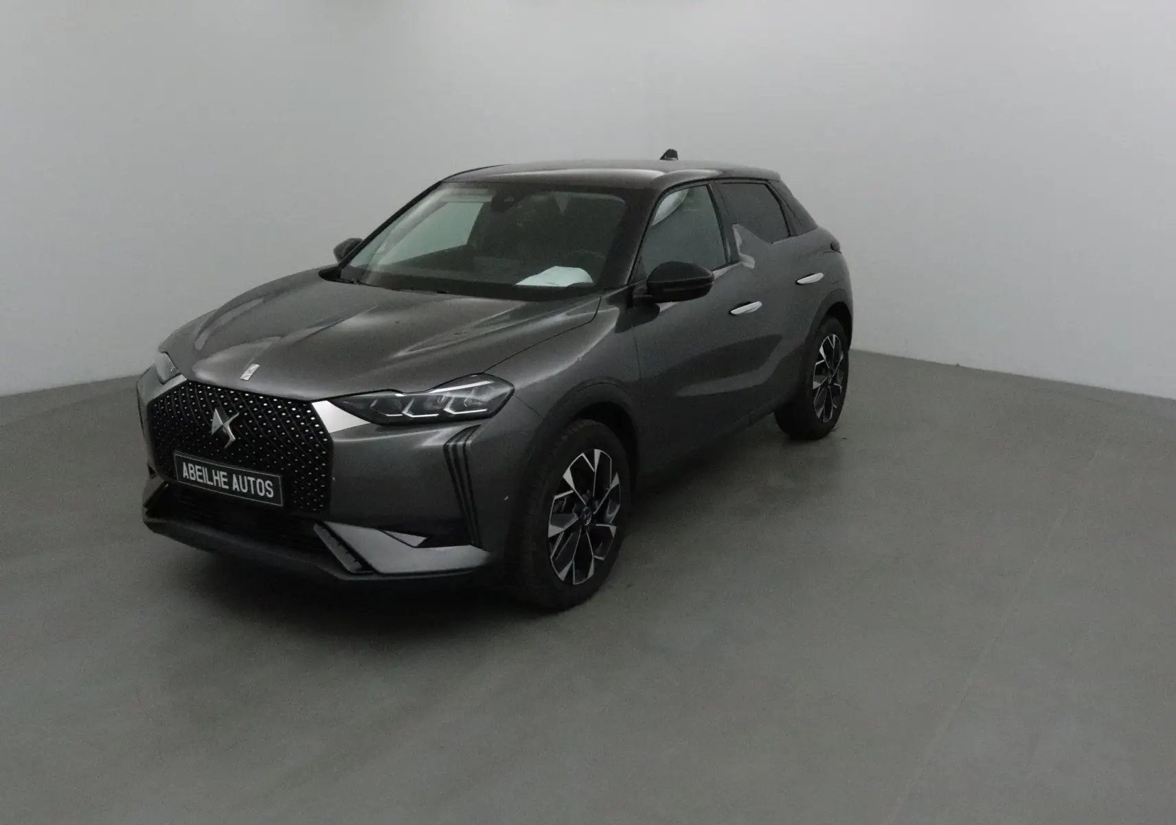 DS3 Crossback gris platinium en 3/4 avant droit, avec calandre noire à motifs et jantes alliage distinctives.