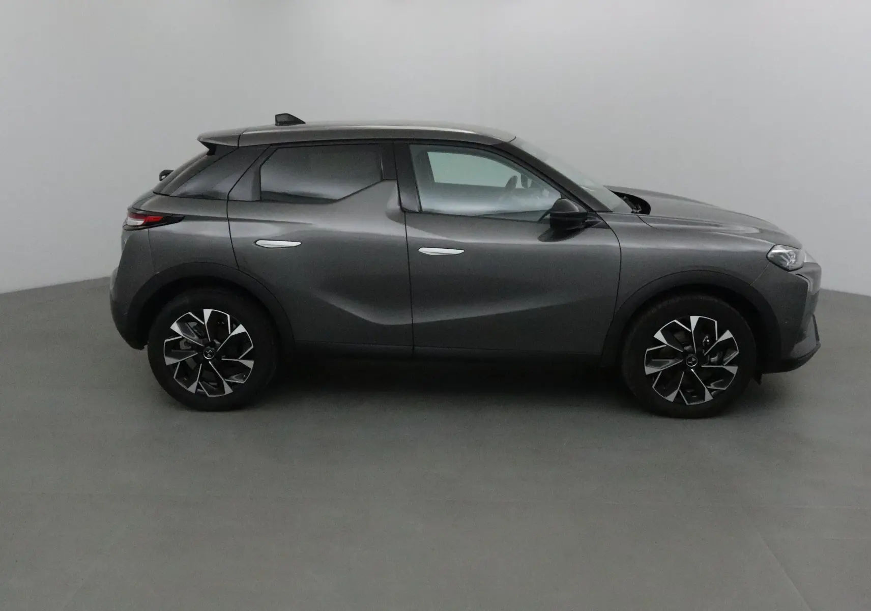Profil côté gauche du DS3 Crossback gris platinium 2024 avec jantes noires et design sculpté des portes.