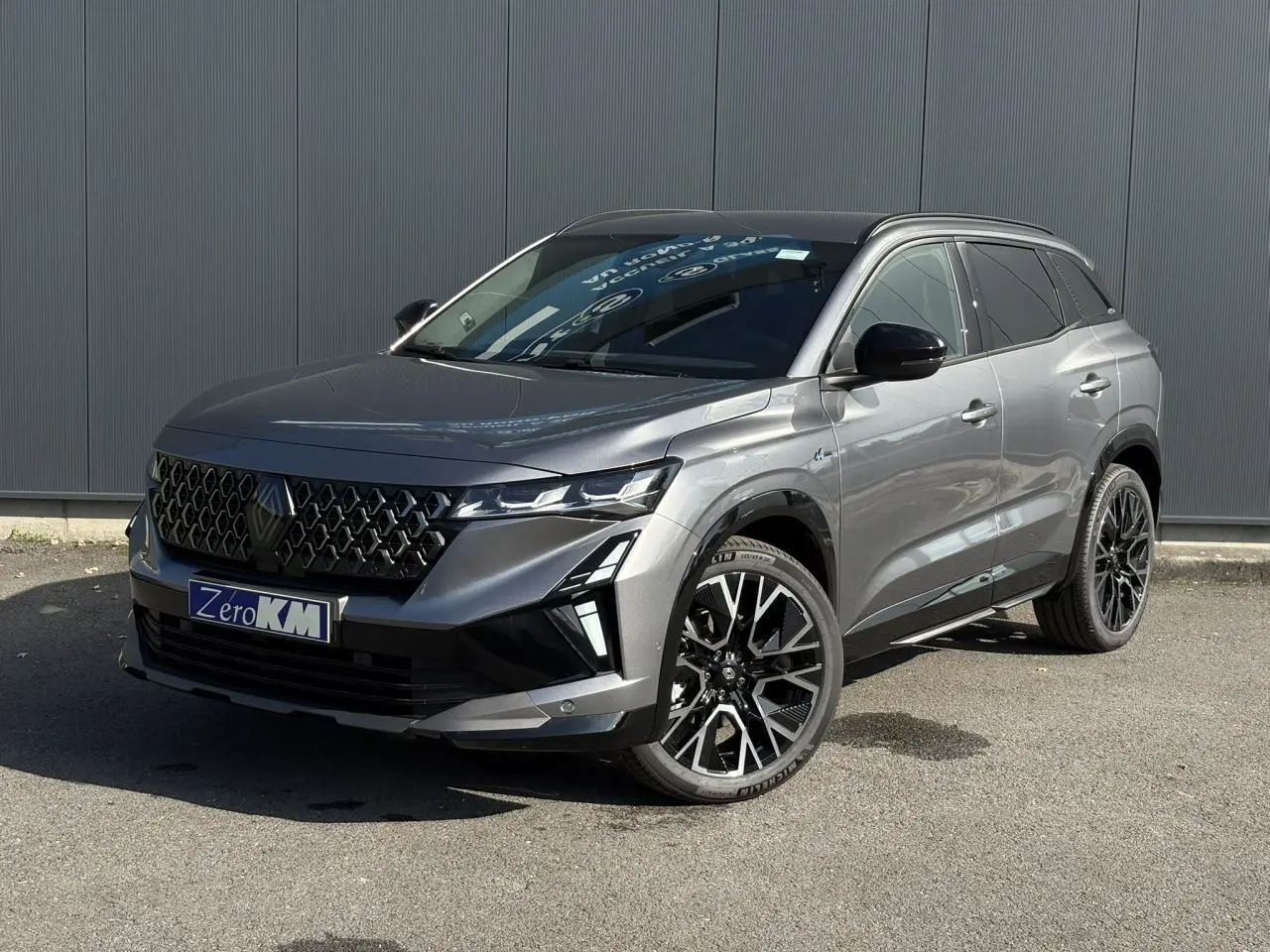 Renault Austral E-Tech gris schiste en 3/4 avant droit avec jantes alliage noires et toit noir brillant.