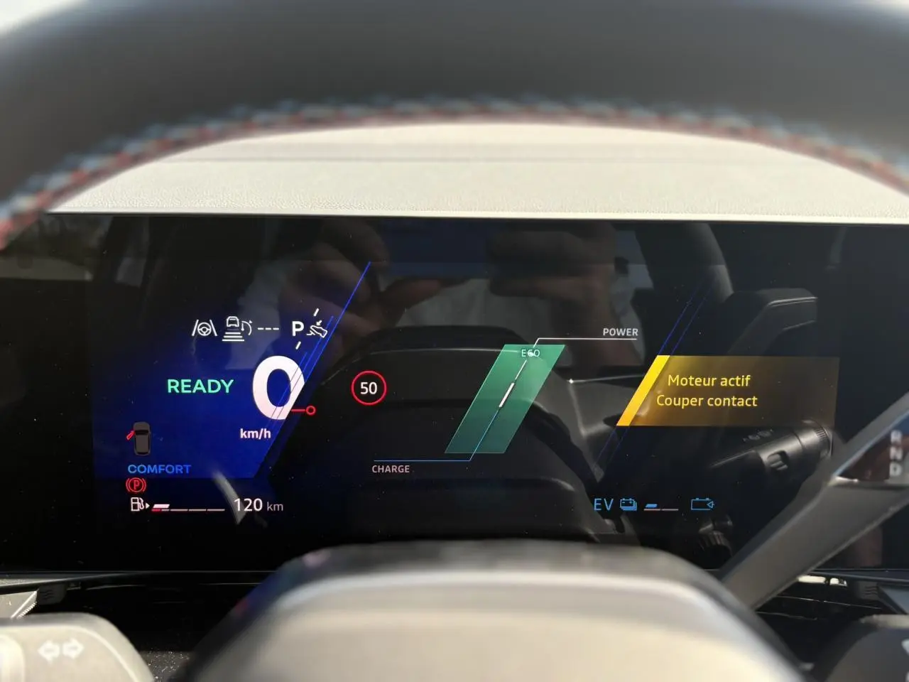 Affichage numérique du tableau de bord du Renault Austral E-Tech gris, montrant la vitesse à zéro et l'alerte moteur actif.