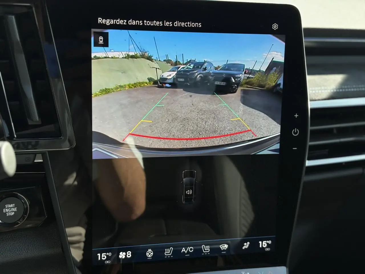 Écran tactile intérieur montrant la caméra de recul du Renault Austral gris Schiste avec lignes de guidage colorées.