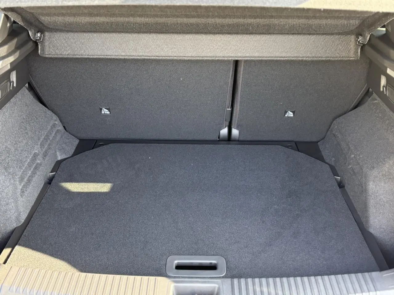 Coffre ouvert vu de face du Renault Austral gris Schiste, montrant un espace de chargement propre et bien fini.