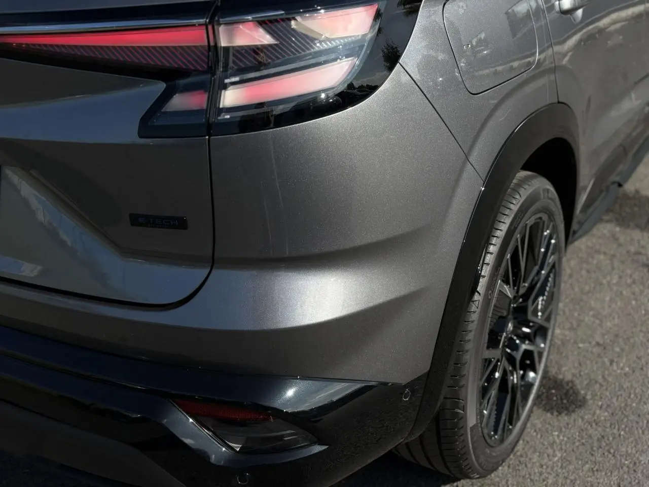 Gros plan sur l'arrière droit gris schiste du Renault Austral E-Tech avec feux LED et jante alliage noire.