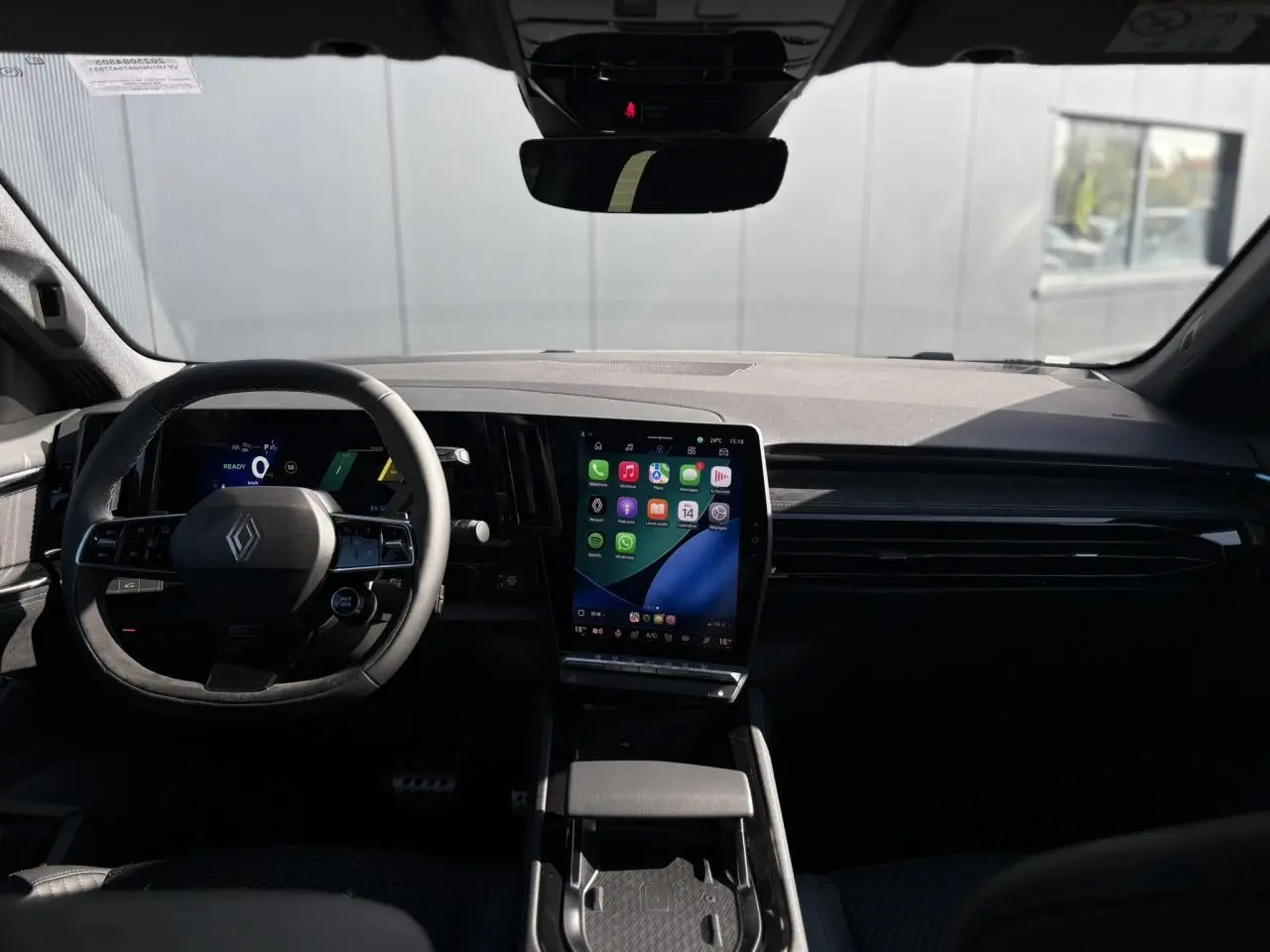 Vue intérieure du tableau de bord du Renault Austral gris Schiste, avec écran tactile vertical et volant multifonction.