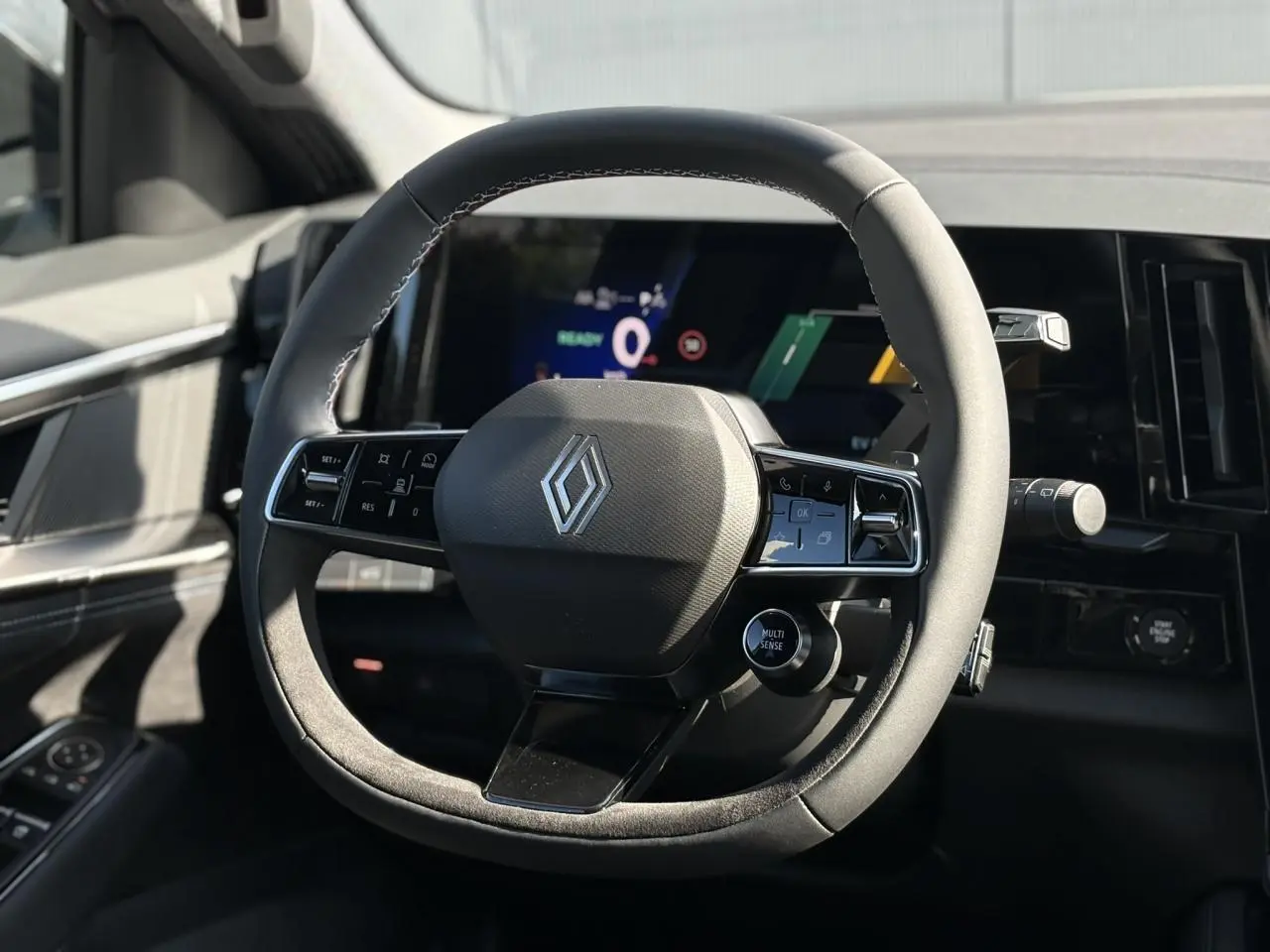 Volant textile Alcantara avec logo Renault, cadrans numériques et commandes intégrées, intérieur noir du Renault Austral E-Tech.