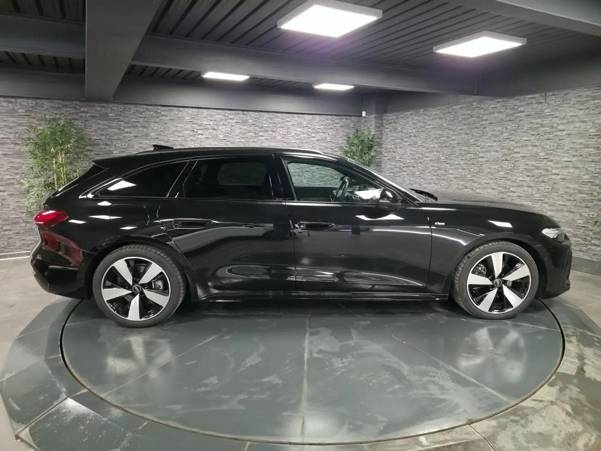 Profil côté gauche d'une Audi A5 Avant S line noire 2025 avec jantes 5 branches doubles et vitres surteintées.