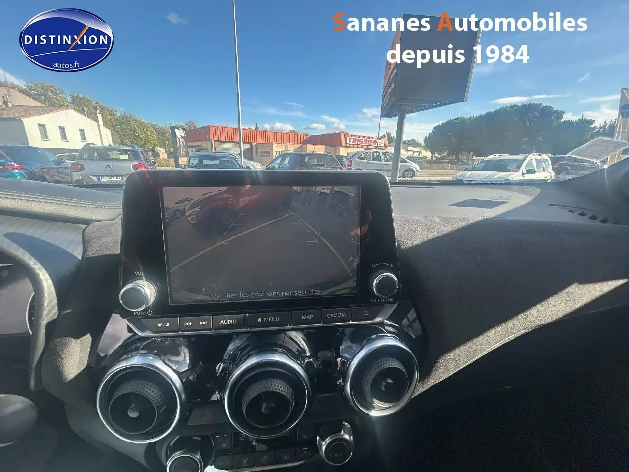 Vue intérieure du tableau de bord du Nissan Juke 2020 avec écran tactile affichant la caméra de recul.