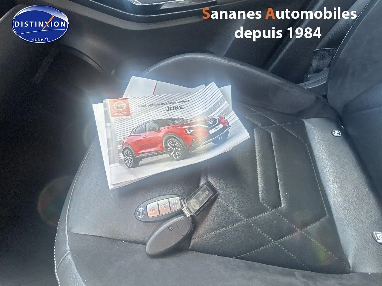 Gros plan sur le siège avant droit en cuir noir avec clé Nissan et brochure du Juke posées dessus.
