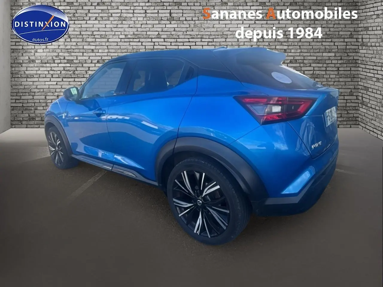 Vue 3/4 arrière droite d'un Nissan Juke bleu clair métallisé, soulignant ses jantes noires à motifs argentés.