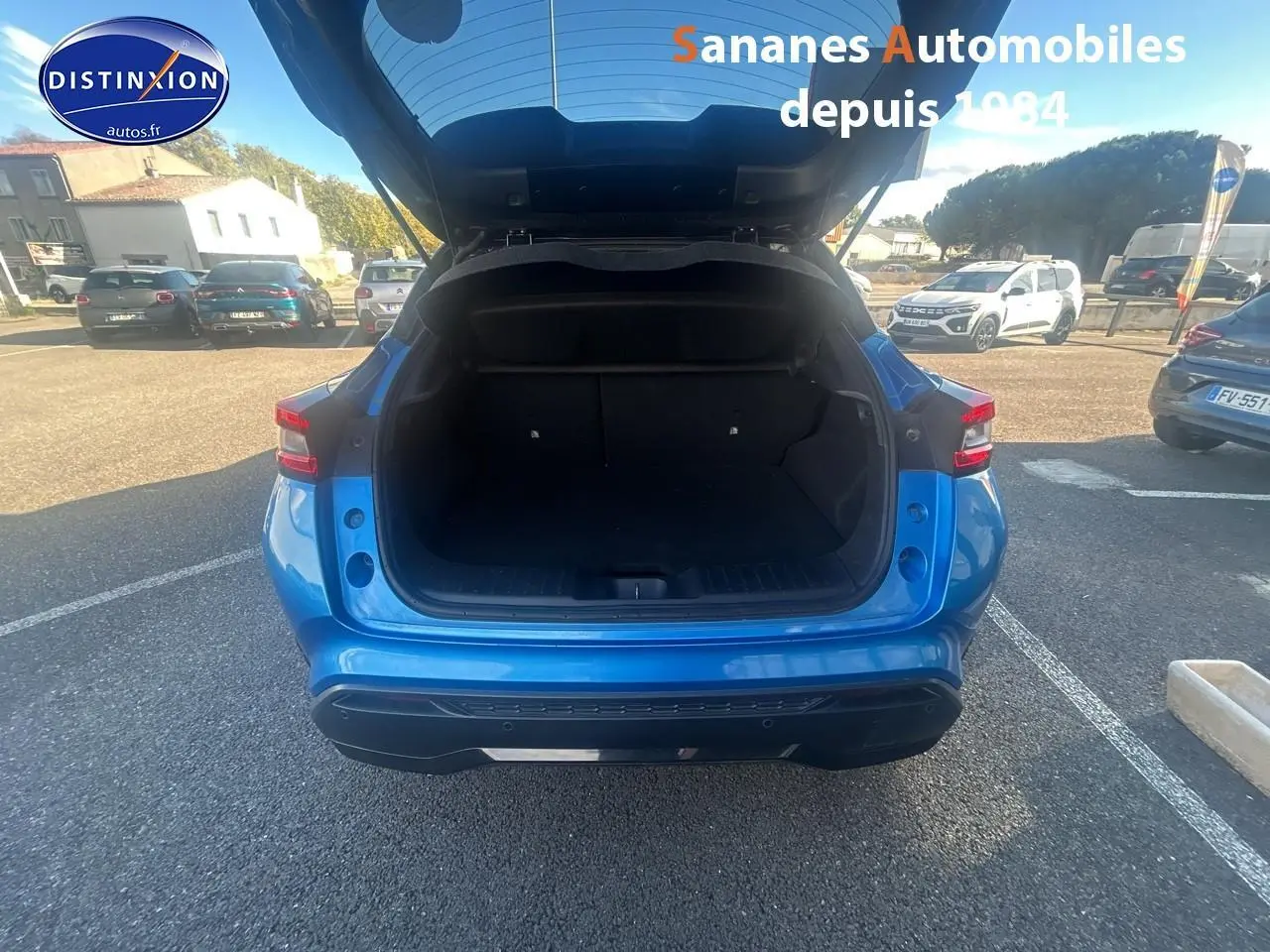 Vue arrière du Nissan Juke bleu clair 2020 avec coffre ouvert, montrant l'espace de chargement vide.