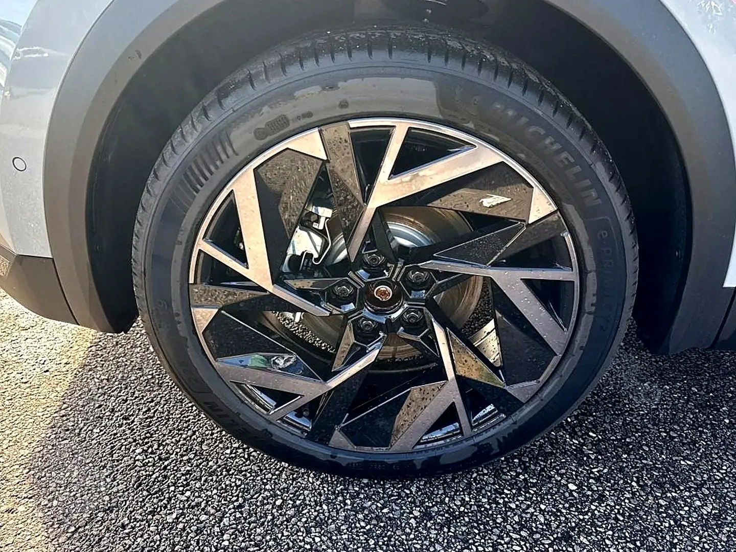 Gros plan sur la roue avant droite du Renault Symbioz gris rafale, mettant en valeur la jante alu au design géométrique noir et argent.