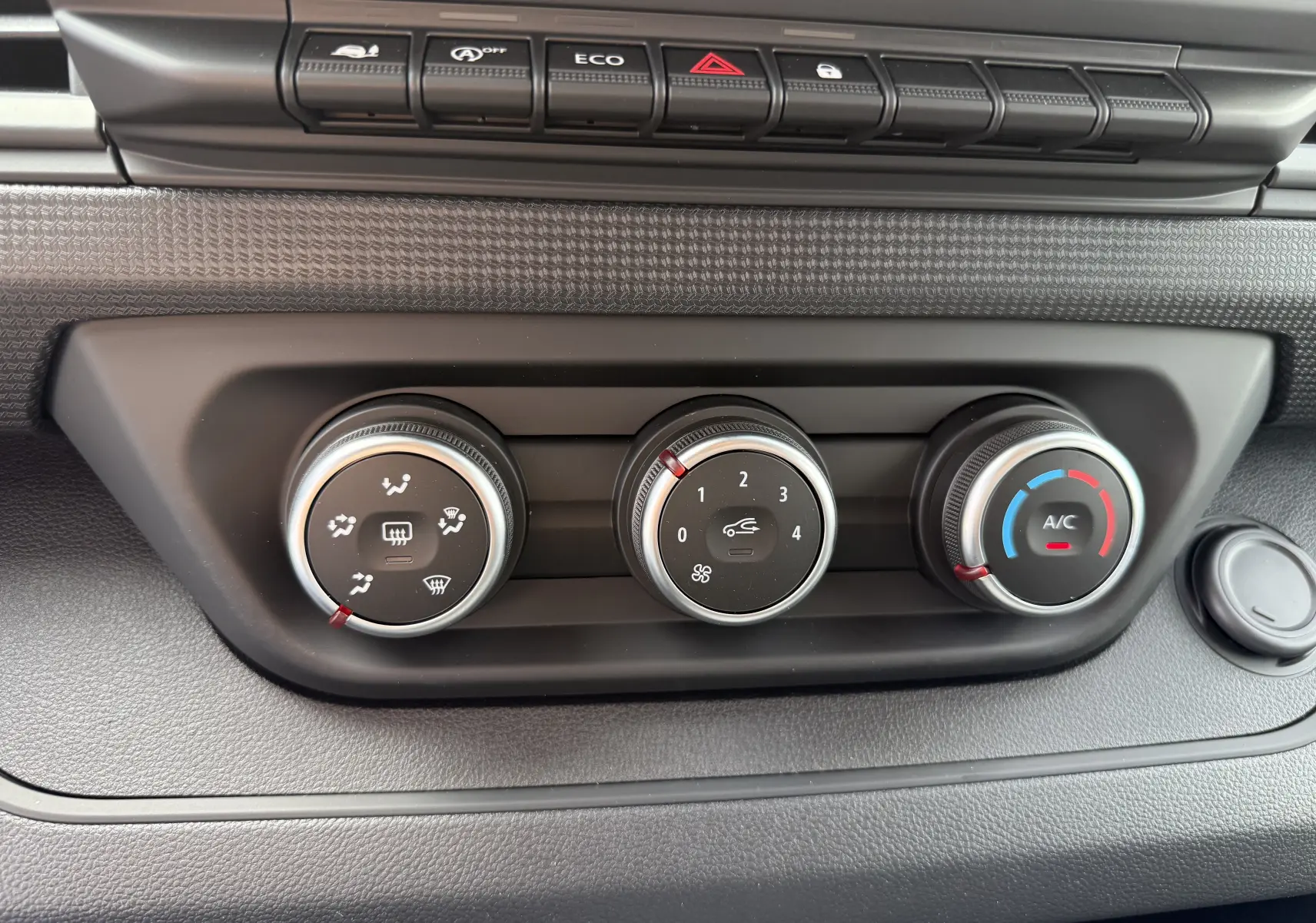 Commandes de climatisation du Renault Trafic Combi L2 Grand Evolution 2025 en gros plan, avec boutons rotatifs noirs et détails argentés.