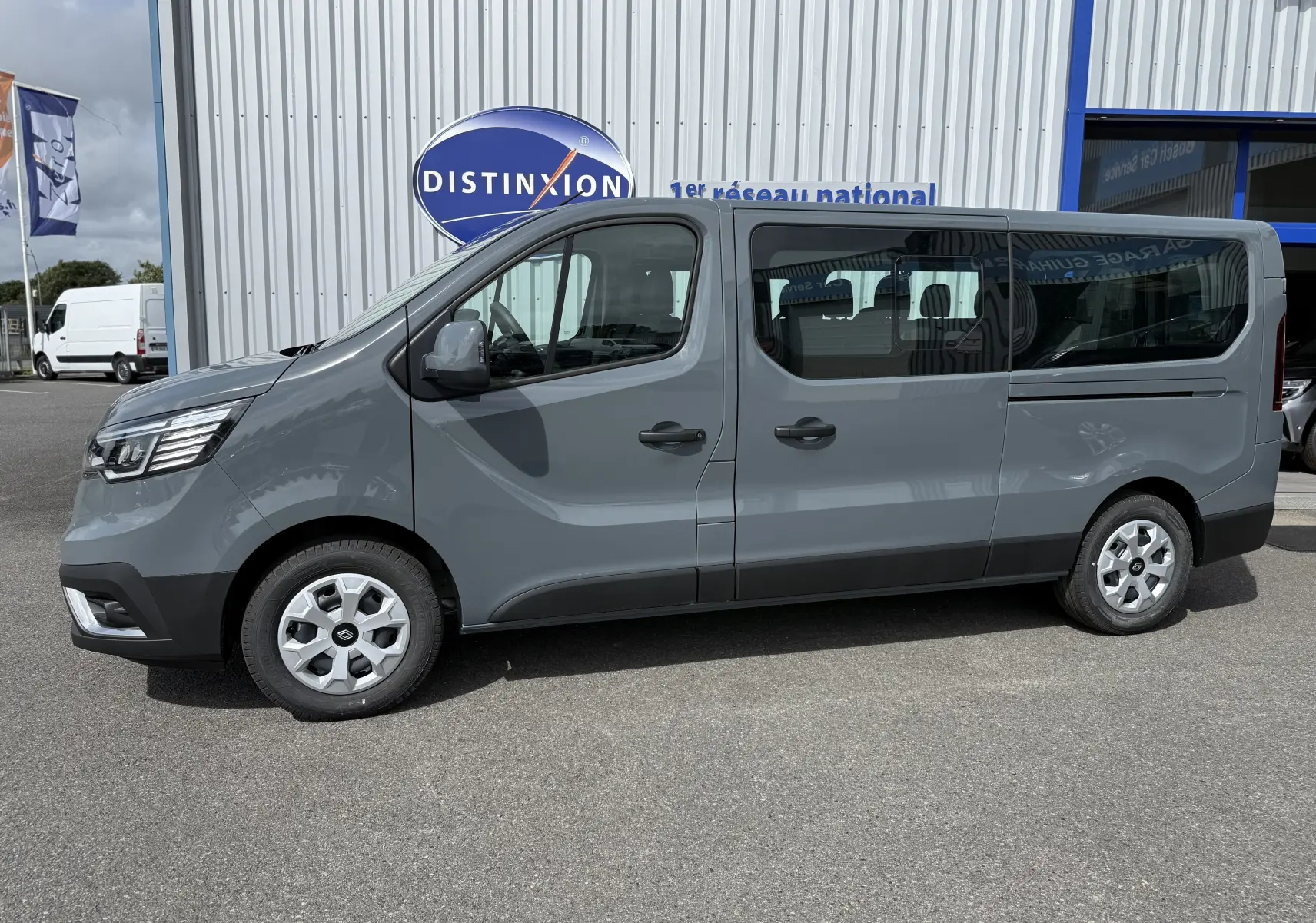 Profil côté gauche d'un Renault Trafic Combi gris Urban 2025, avec fenêtres teintées et jantes acier.