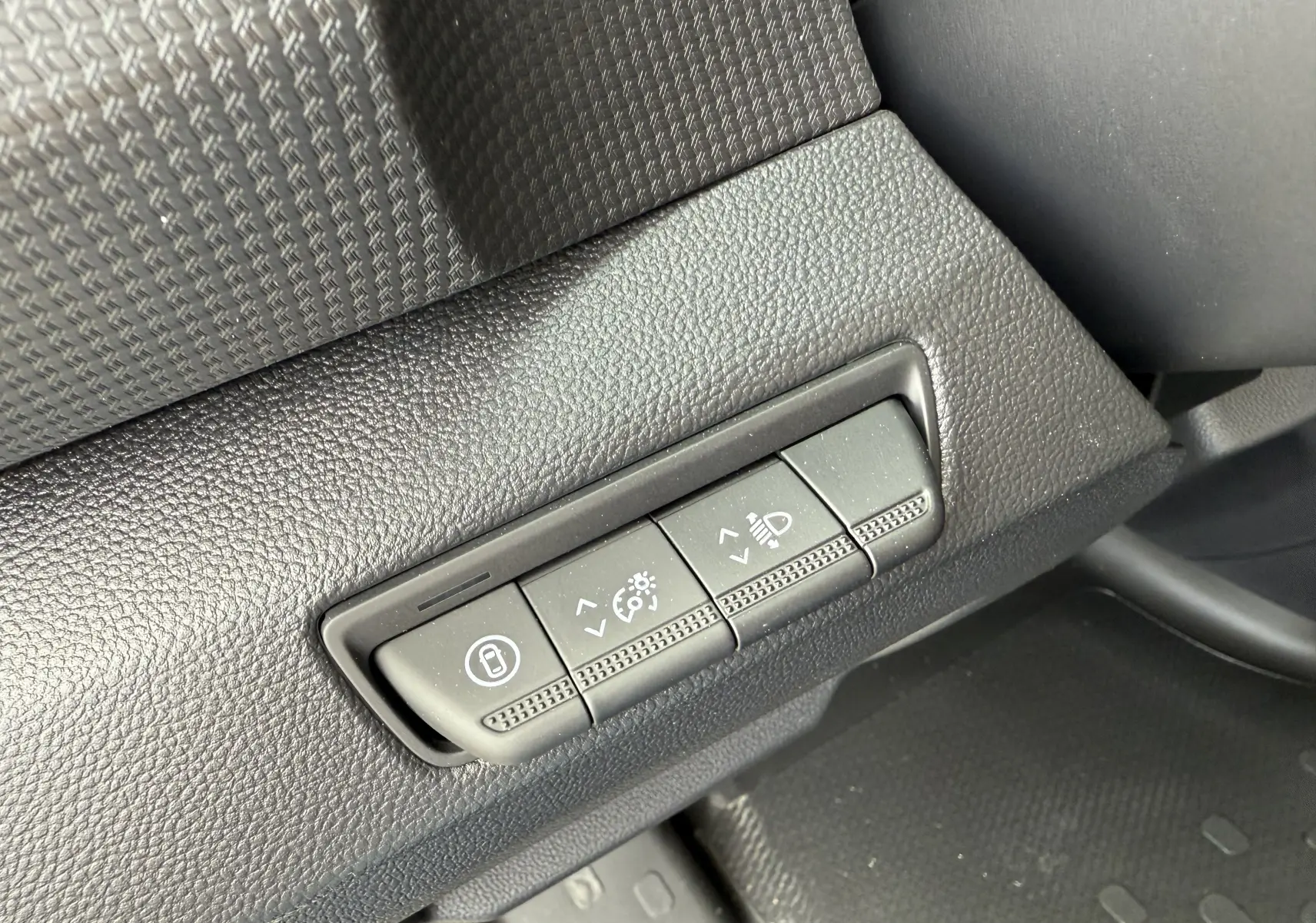 Gros plan sur les commandes de réglage du tableau de bord du Renault Trafic Combi gris, côté gauche conducteur.