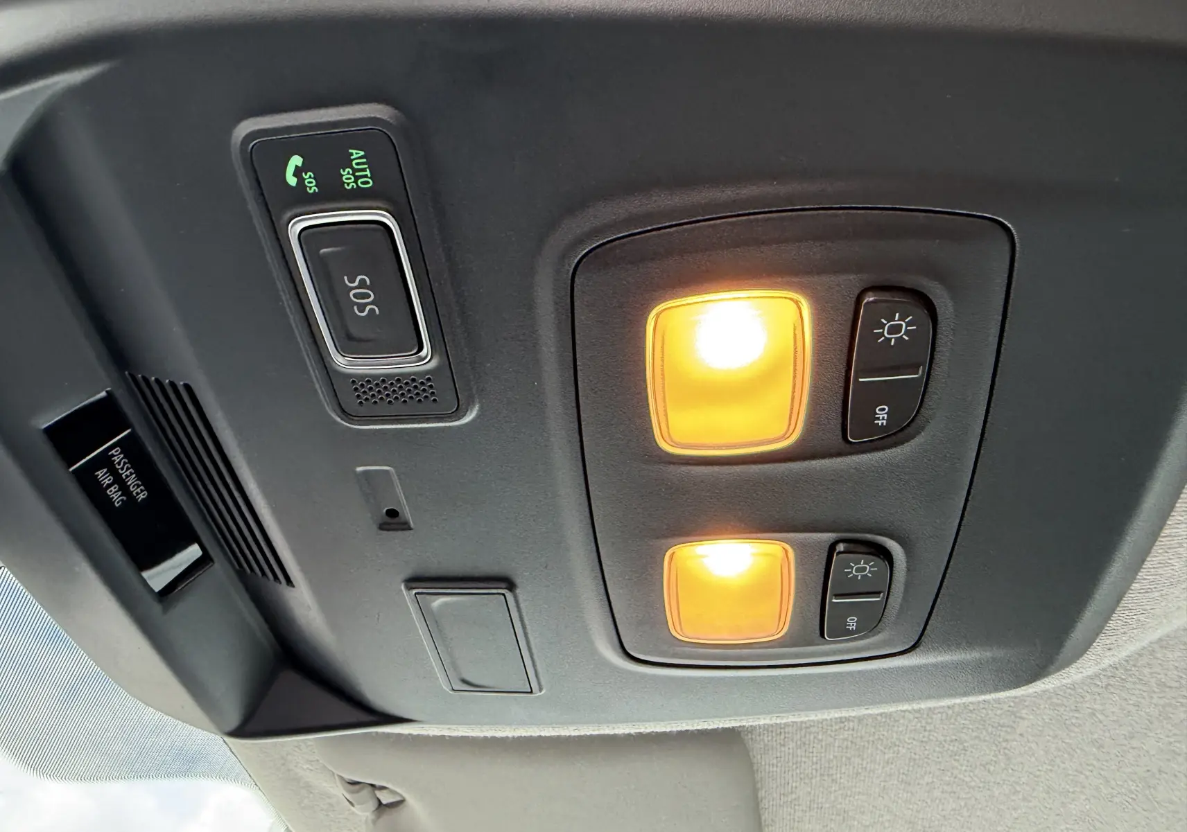 Plafonnier avant allumé avec commandes d'éclairage et bouton SOS dans un Renault Trafic Combi gris Urban 2025.