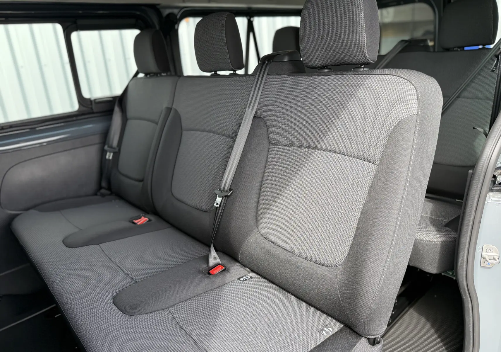 Banquette arrière en tissu gris vue de côté gauche dans le Renault Trafic Combi L2 Grand Evolution 2025.