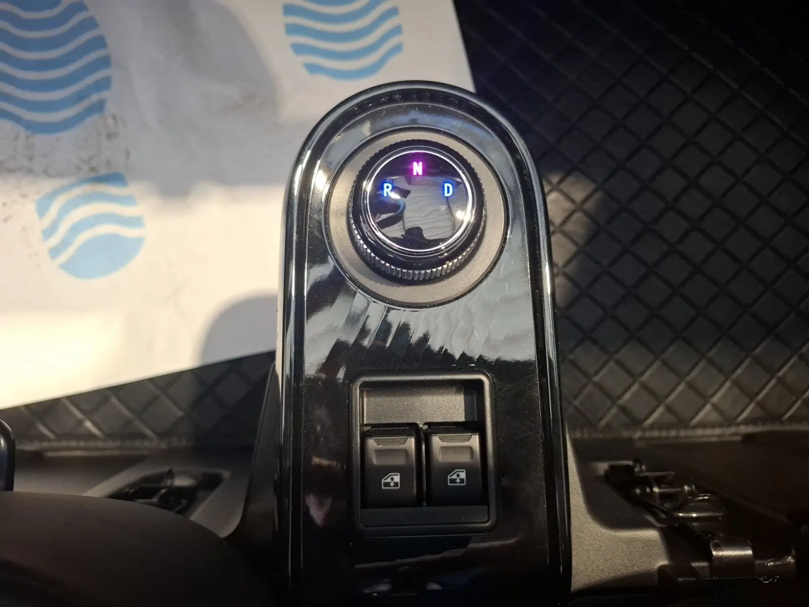 Gros plan sur la commande de boîte automatique et les boutons de lève-vitres dans l’habitacle du Simplici S1 gris perle.