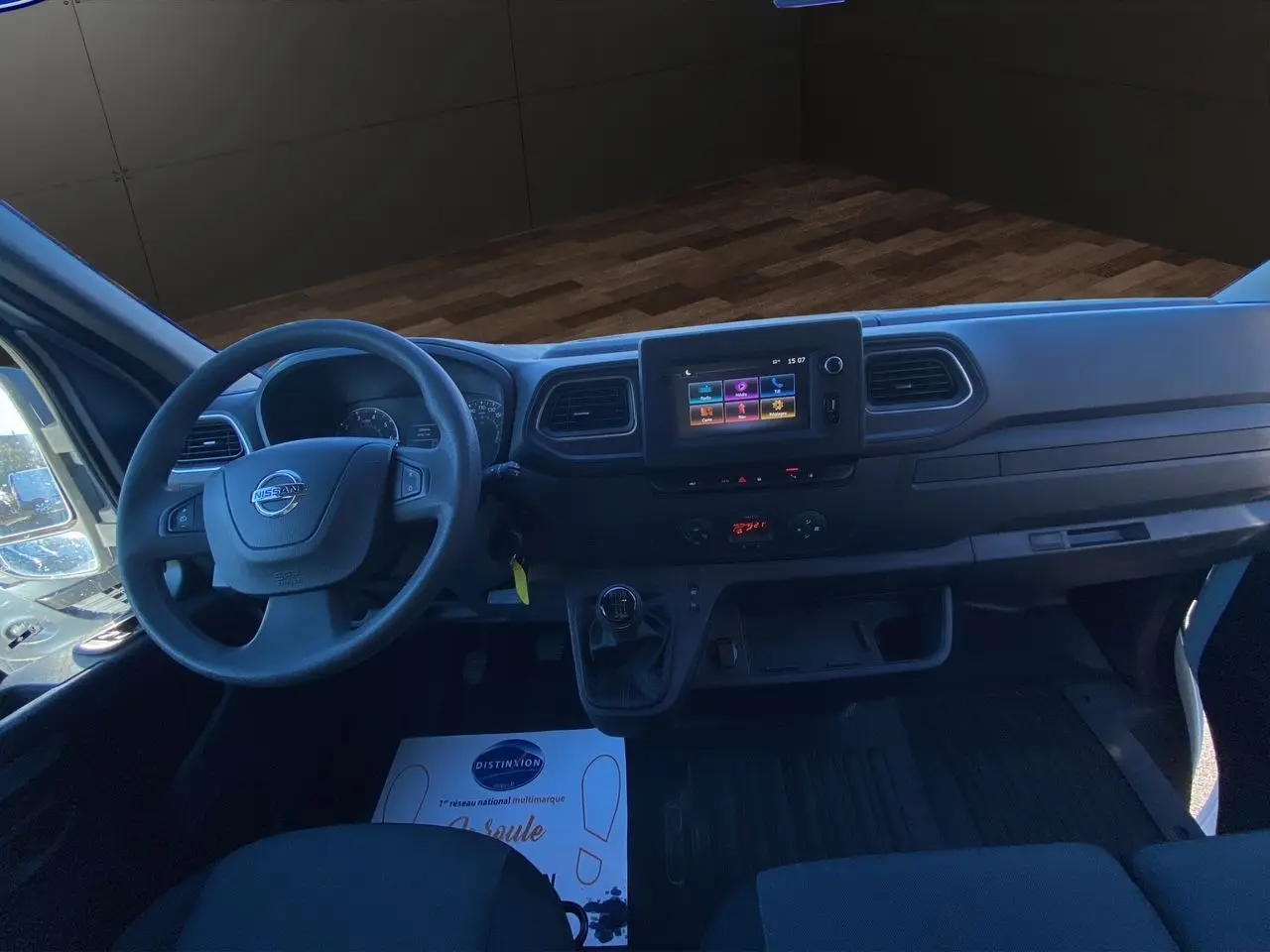 Vue intérieure du poste de conduite du Nissan Interstar blanc, avec tableau de bord moderne et écran tactile central.